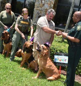 Col. Alvin Pollock of the Broward Sheriff’s Office thanks Suzie and her handler, Kevin Bolling, for her years of service in tracking missing children and vulnerable adults on June 1 at BSO’s Parkland district office.